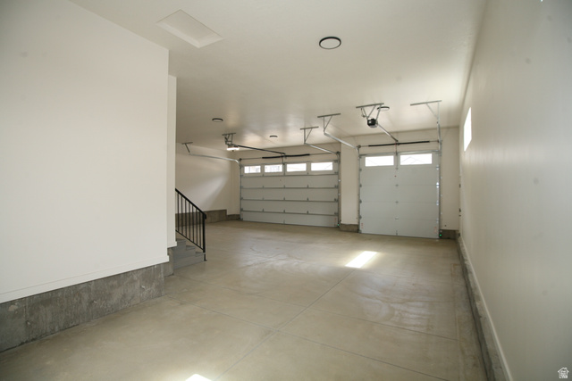 635 East Mountain Road North Ogden, UT 84414 - Photo 28 of 33 Spacious three-car garage featuring a concrete floor, white walls, and two overhead garage doors with frosted window inserts