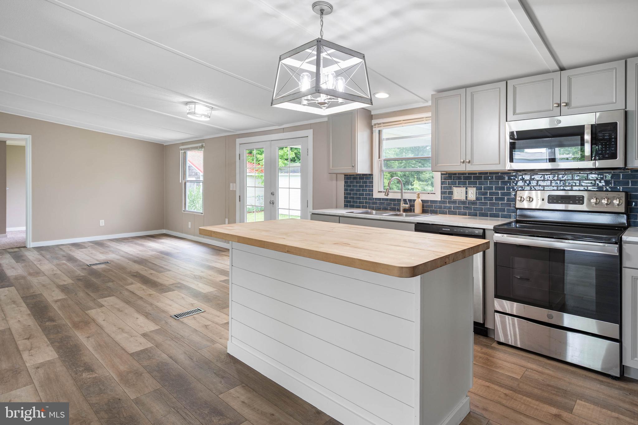 31392 Oak Street Ocean View, DE 19970 - Photo 11 of 38 a kitchen with stainless steel appliances granite countertop a sink and a stove