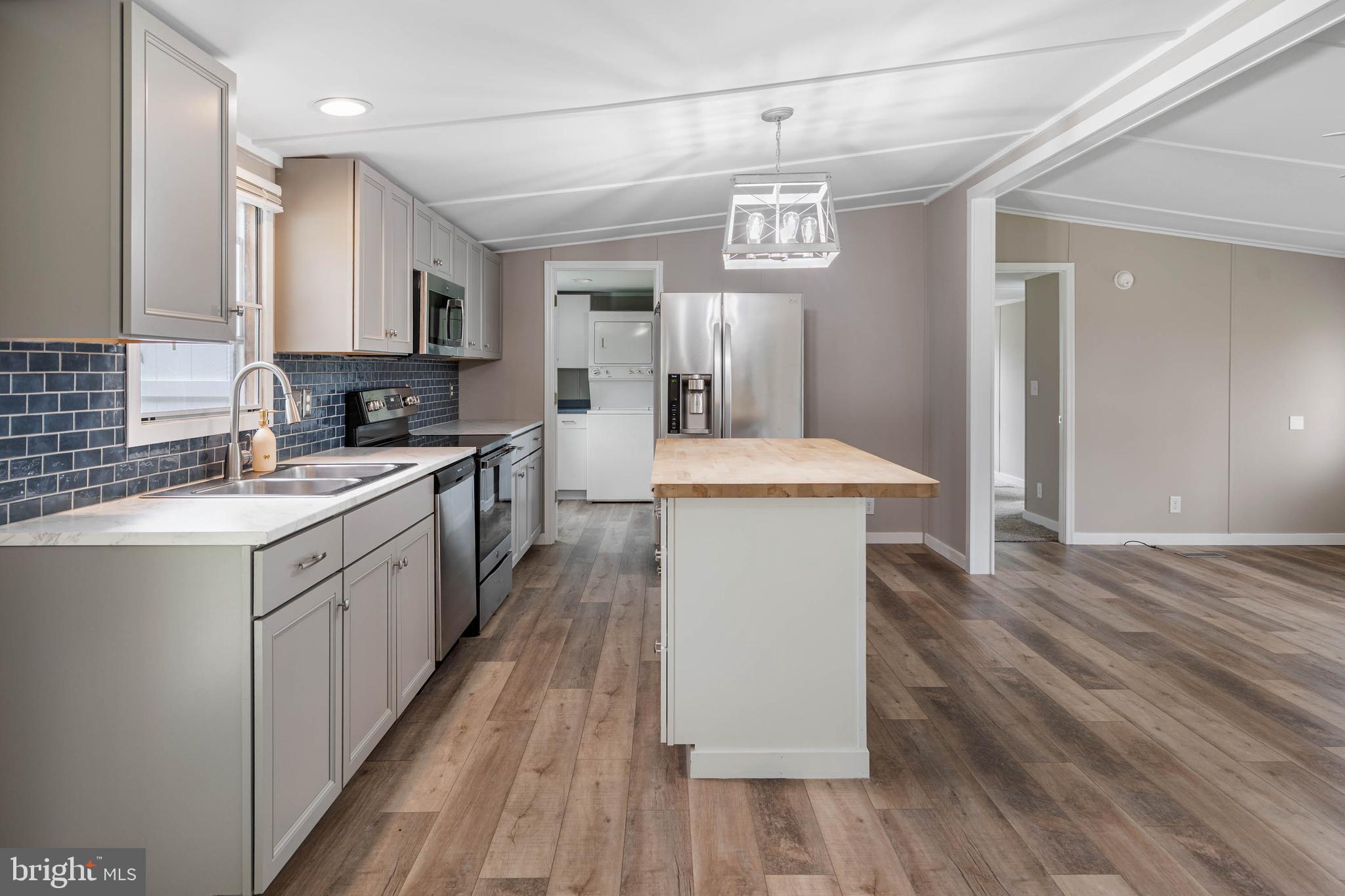 31392 Oak Street Ocean View, DE 19970 - Photo 12 of 38 a large kitchen with stainless steel appliances a large counter top a sink a stove and a refrigerator