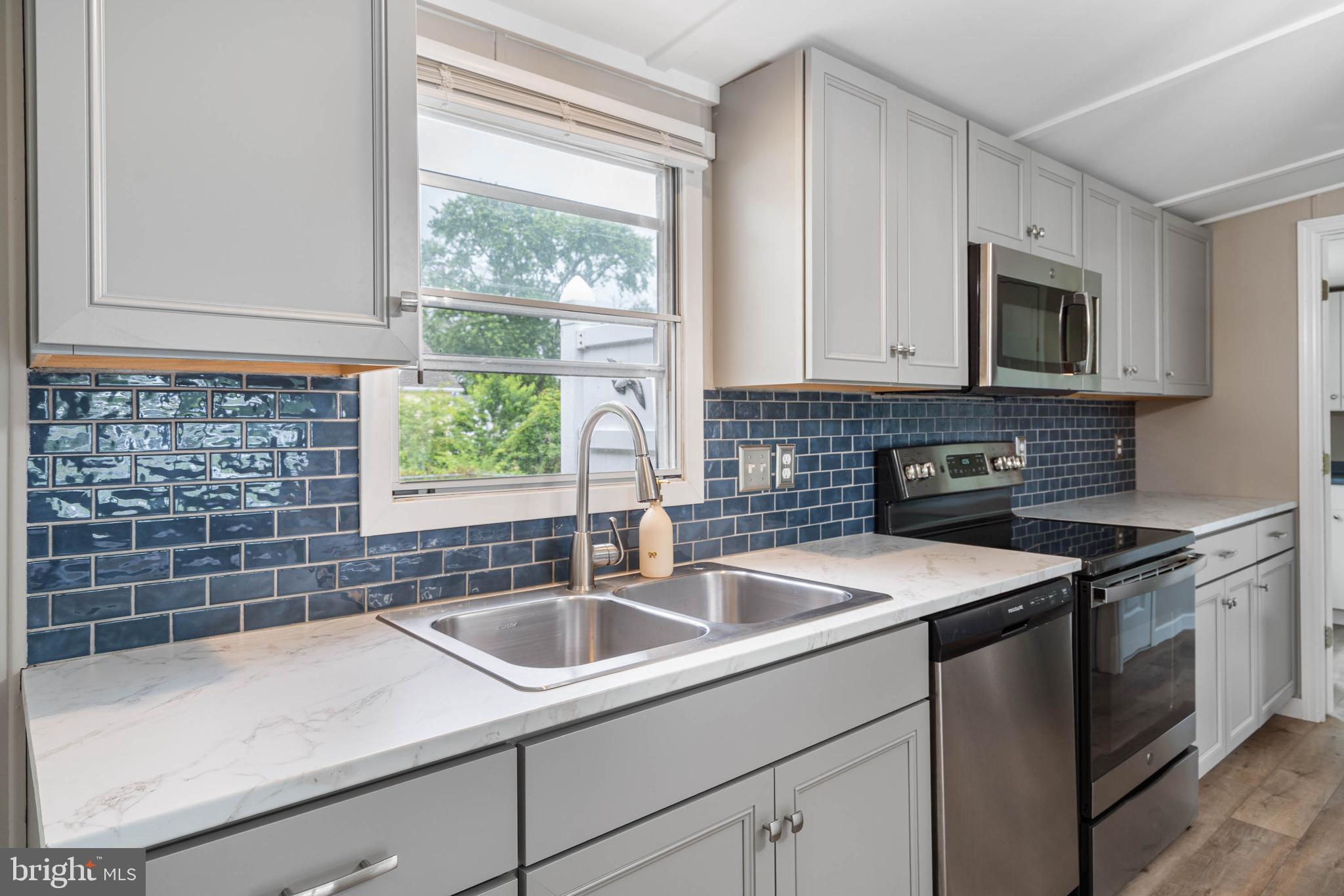 31392 Oak Street Ocean View, DE 19970 - Photo 13 of 38 a kitchen with stainless steel appliances granite countertop a sink stove and cabinets