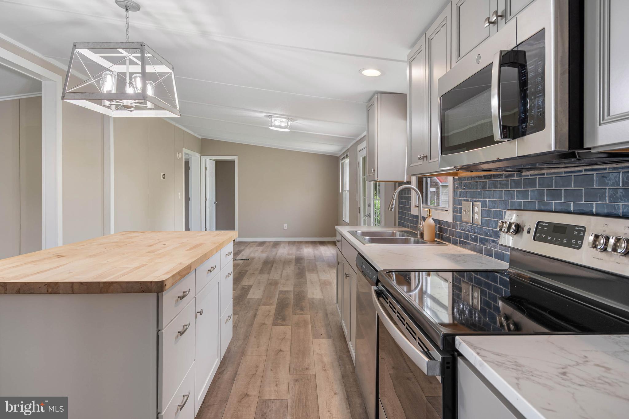 31392 Oak Street Ocean View, DE 19970 - Photo 14 of 38 a kitchen with stainless steel appliances granite countertop a sink and stove