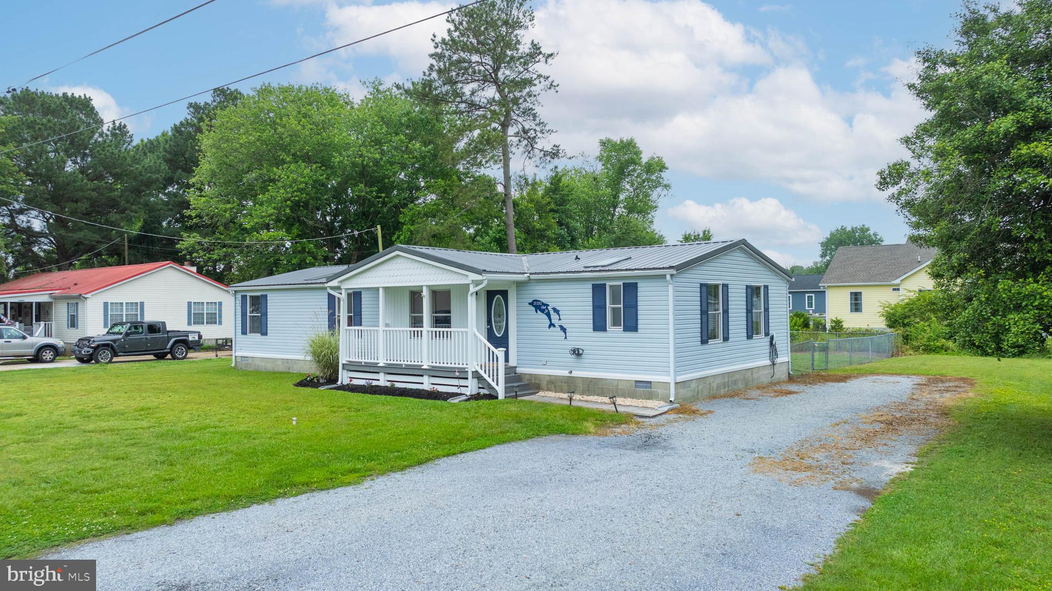 31392 Oak Street Ocean View, DE 19970 - Photo 4 of 38 a front view of a house with a garden and trees