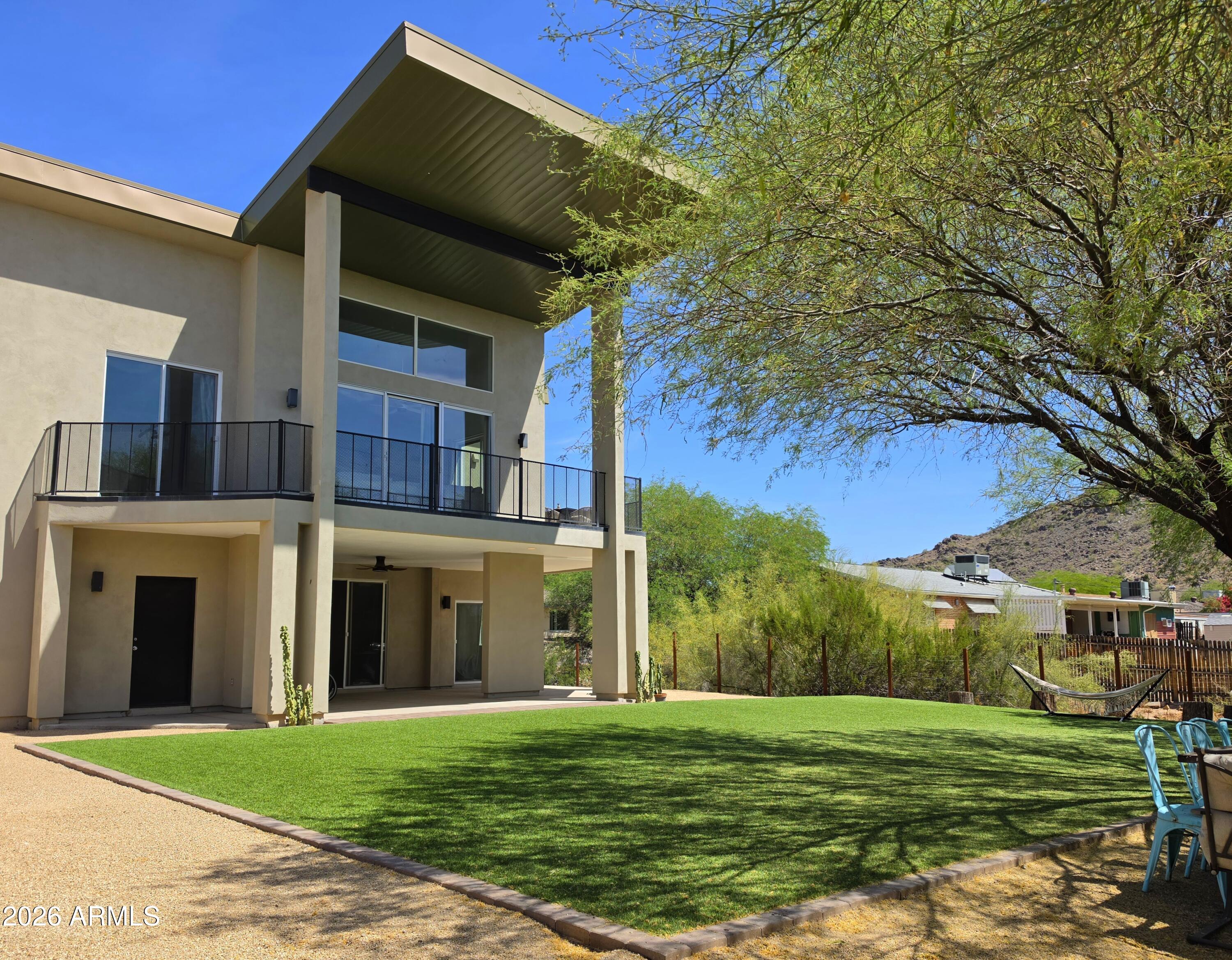 a view of a big house with a big yard and large trees