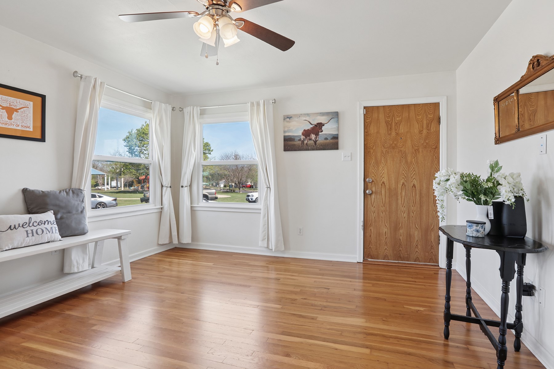 Living area with light wood-style floors and ceiling fan