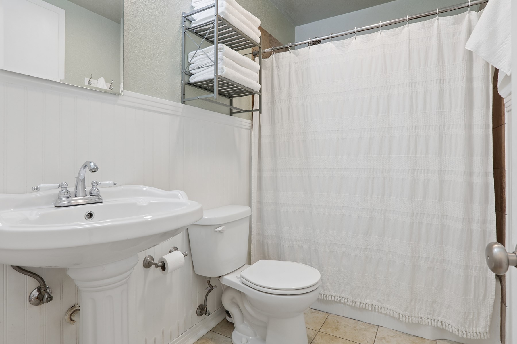 2210 Monticello Road Temple, TX 76501 - Photo 6 of 34 Full bath featuring curtained shower, wainscoting, light tile patterned flooring, and a textured wall
