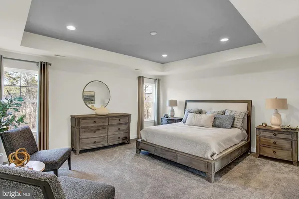 a spacious bedroom with a bed and a chair