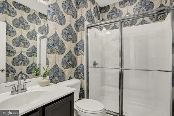 a bath room with a granite countertop toilet sink and mirror