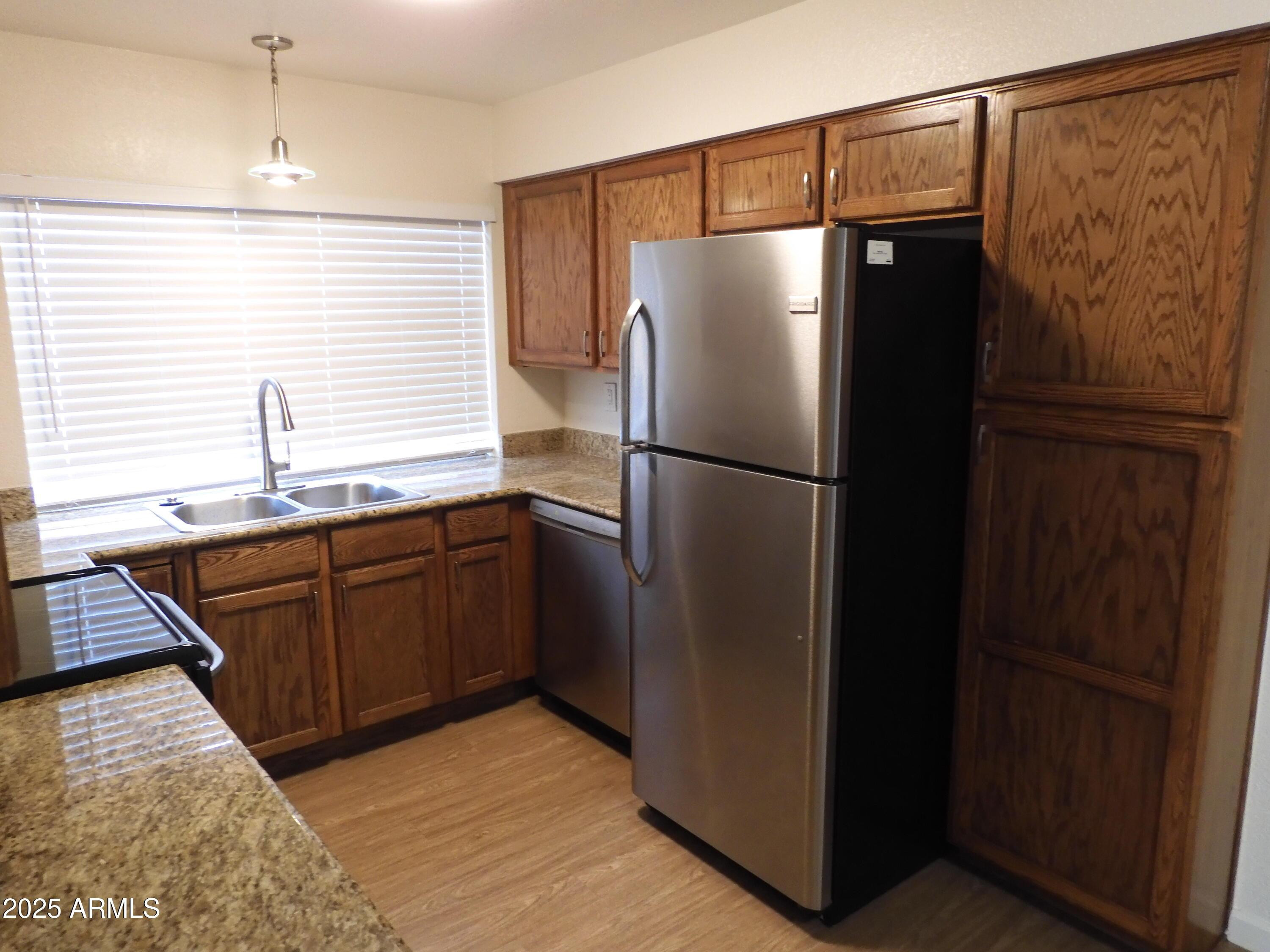 154 West 5th Street, Unit 242 Tempe, AZ 85281 - Photo 11 of 27 a kitchen with stainless steel appliances granite countertop a refrigerator and a sink