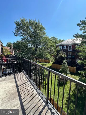 a balcony with wooden floor and city view