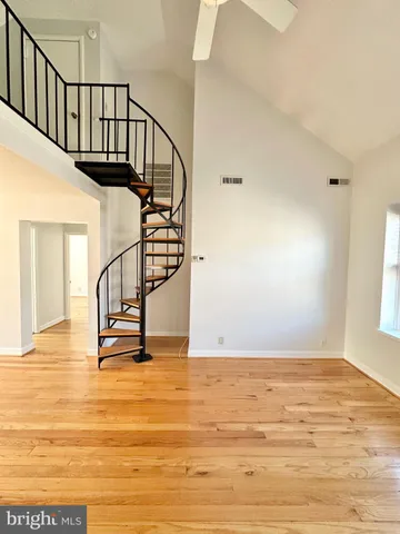 a view of staircase with wooden floor and white walls
