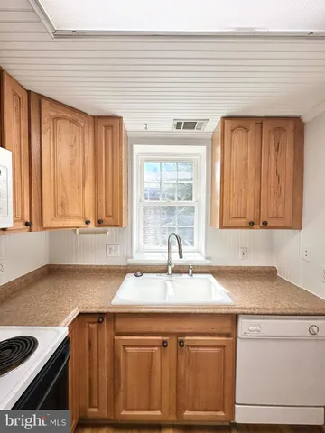 a kitchen with a sink cabinets and a window