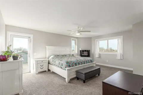 a spacious en suite bathroom with a granite countertop sink and a mirror