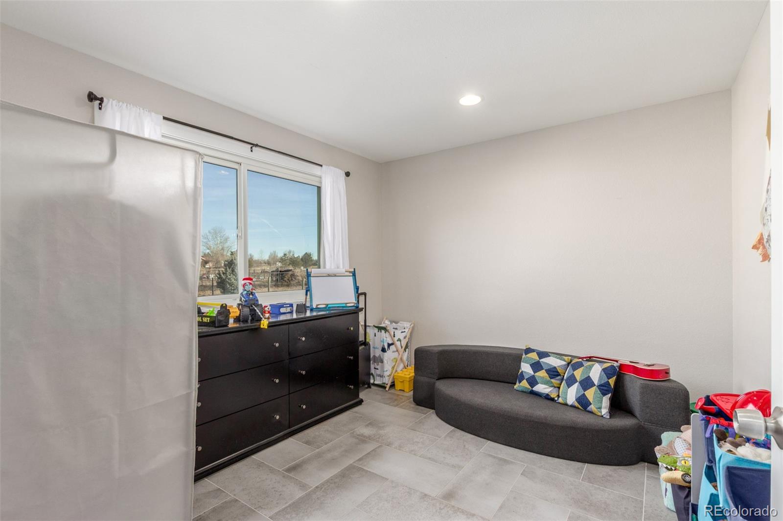 15528 Nancy Avenue Fort Lupton, CO 80621 - Photo 21 of 35 a living room with furniture and a toys