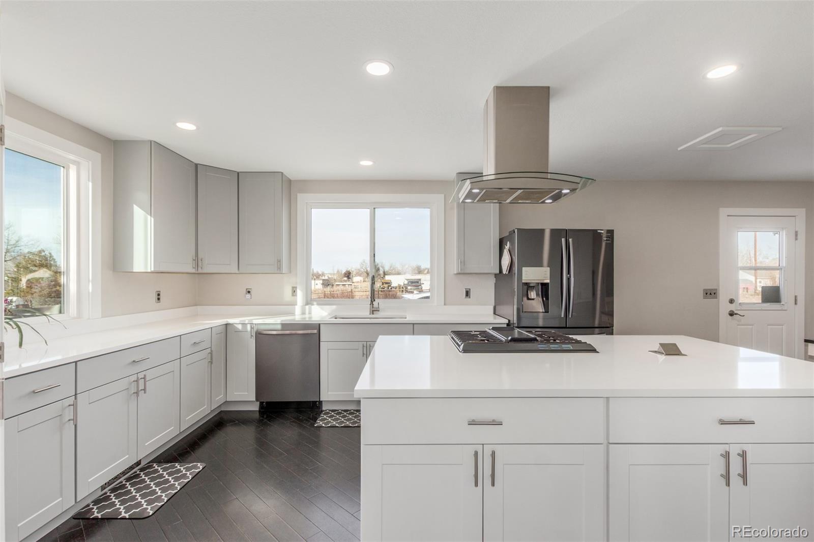 15528 Nancy Avenue Fort Lupton, CO 80621 - Photo 4 of 35 a kitchen with kitchen island a sink appliances and cabinets