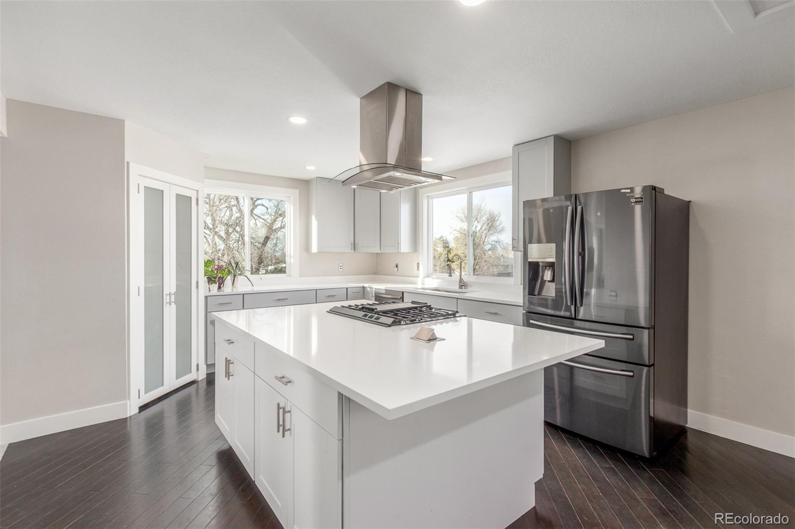 15528 Nancy Avenue Fort Lupton, CO 80621 - Photo 6 of 35 a kitchen with kitchen island a stove a sink and a refrigerator