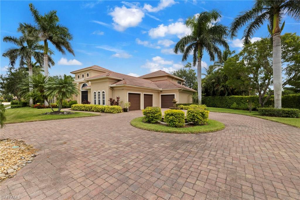 7834 Classics Drive Naples, FL 34113 - Photo 2 of 37 a view of a white house with a yard and potted plants