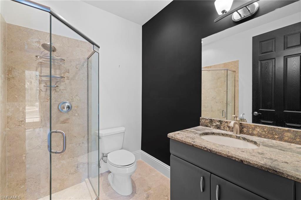 7834 Classics Drive Naples, FL 34113 - Photo 23 of 37 a bathroom with a granite countertop sink toilet and shower