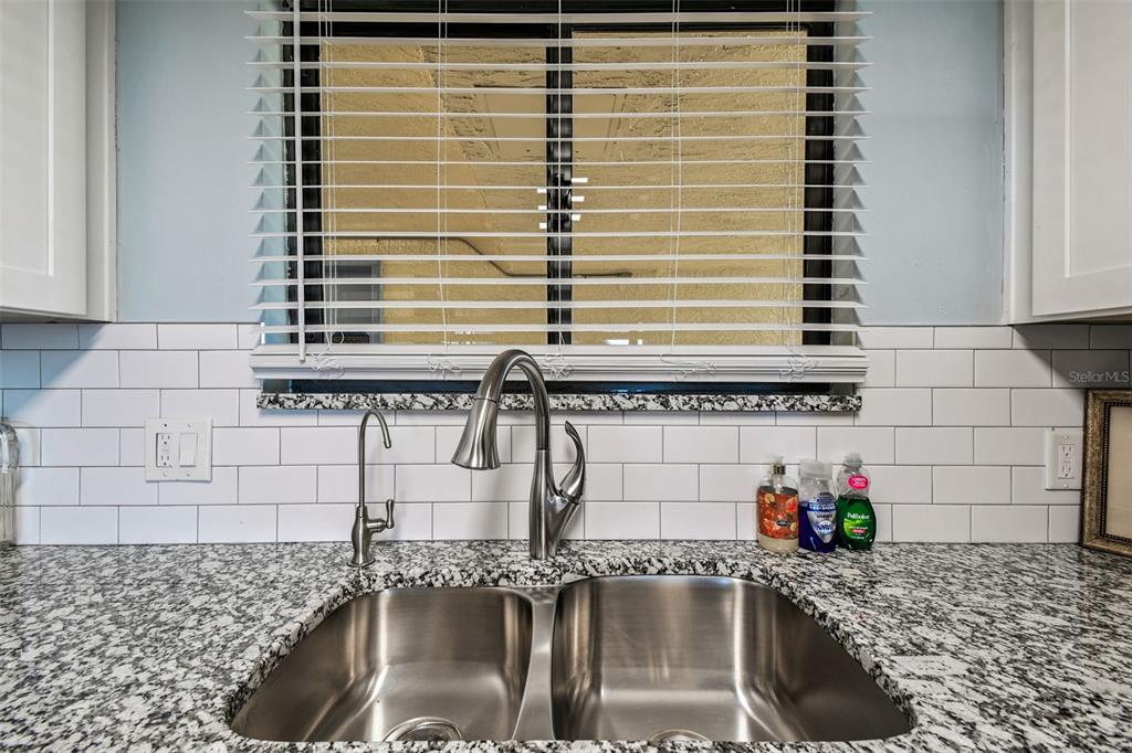 5915 Sea Ranch Drive, Unit 108 Hudson, FL 34667 - Photo 11 of 92 a bathroom with a granite countertop sink and a window