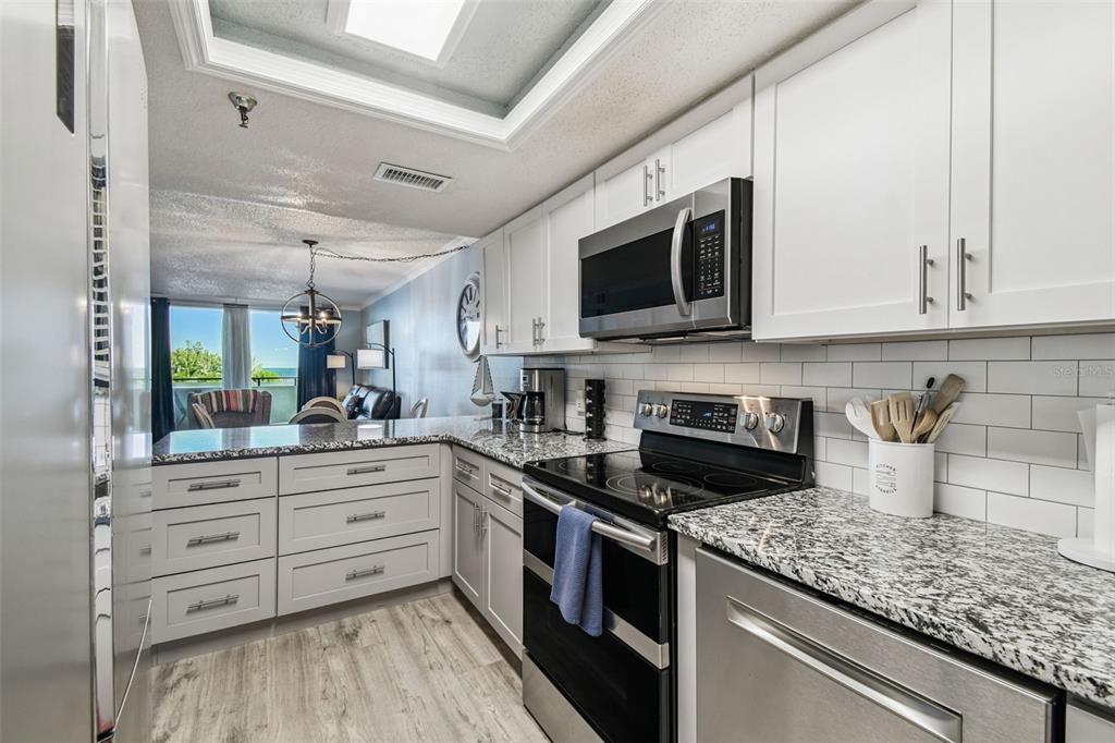 5915 Sea Ranch Drive, Unit 108 Hudson, FL 34667 - Photo 12 of 92 a kitchen with stainless steel appliances granite countertop a stove a sink and a microwave
