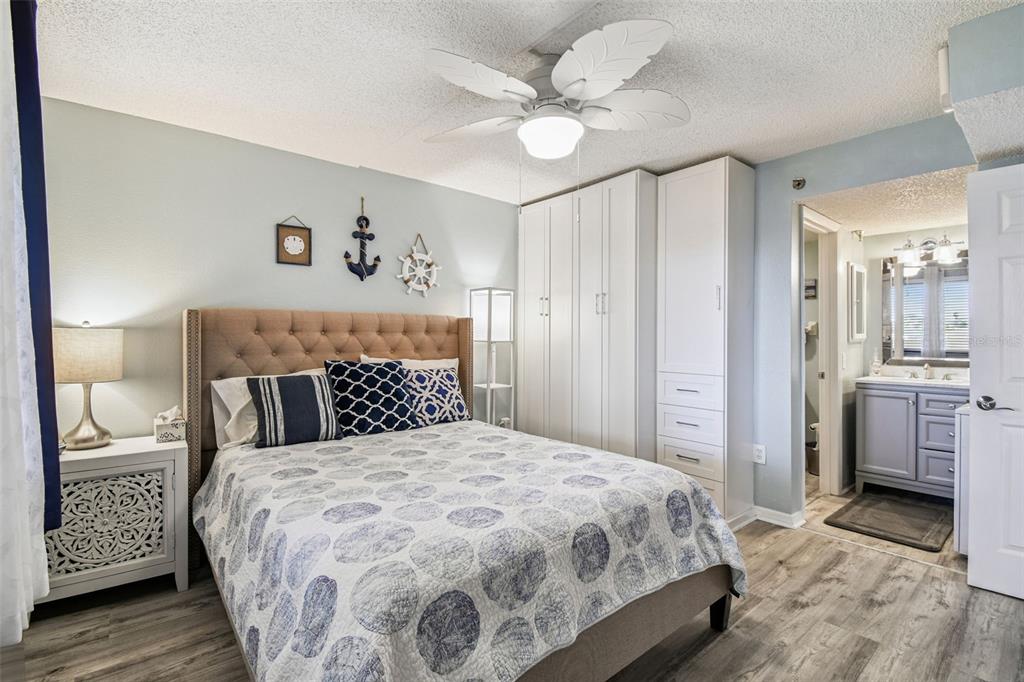 5915 Sea Ranch Drive, Unit 108 Hudson, FL 34667 - Photo 34 of 92 a bedroom with a large bed and a chandelier