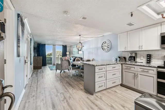 a kitchen with stainless steel appliances granite countertop a refrigerator a stove top oven a sink and dishwasher