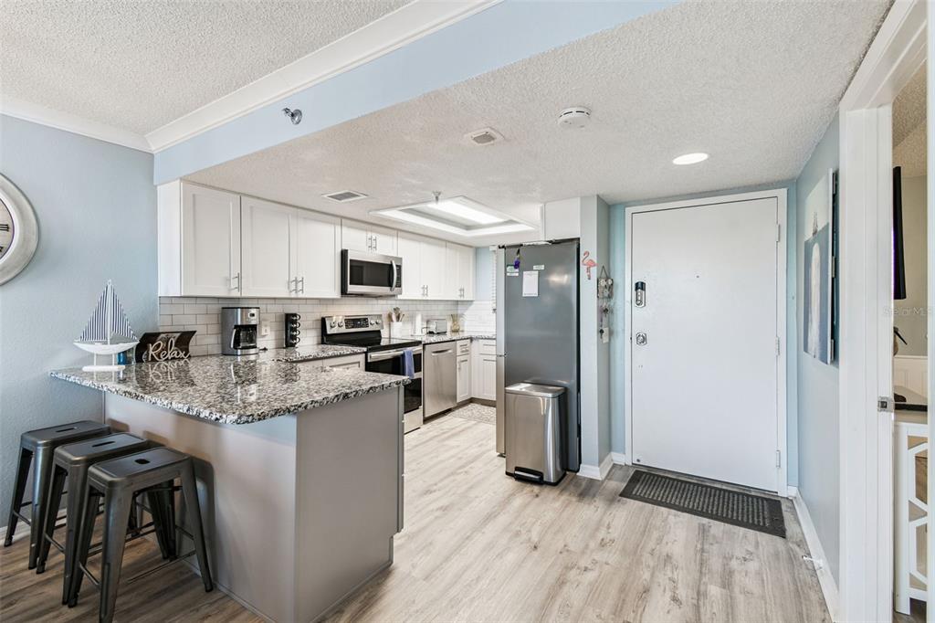 5915 Sea Ranch Drive, Unit 108 Hudson, FL 34667 - Photo 5 of 92 a kitchen with stainless steel appliances granite countertop a refrigerator a stove top oven a sink and dishwasher