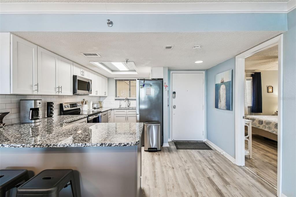 5915 Sea Ranch Drive, Unit 108 Hudson, FL 34667 - Photo 6 of 92 a kitchen with stainless steel appliances granite countertop a refrigerator oven a sink dishwasher and white cabinets with wooden floor