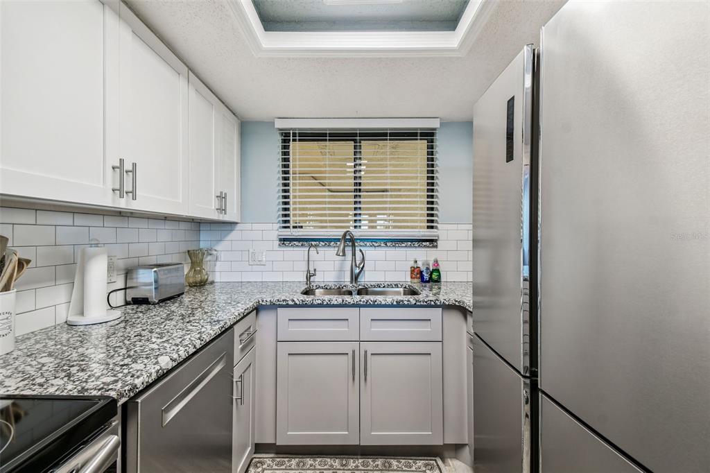 5915 Sea Ranch Drive, Unit 108 Hudson, FL 34667 - Photo 10 of 92 a kitchen with granite countertop a sink and a window