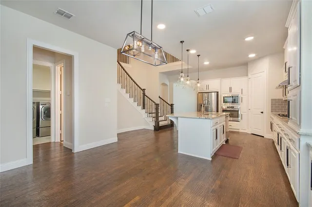 a view of a kitchen and dining room with wooden floor