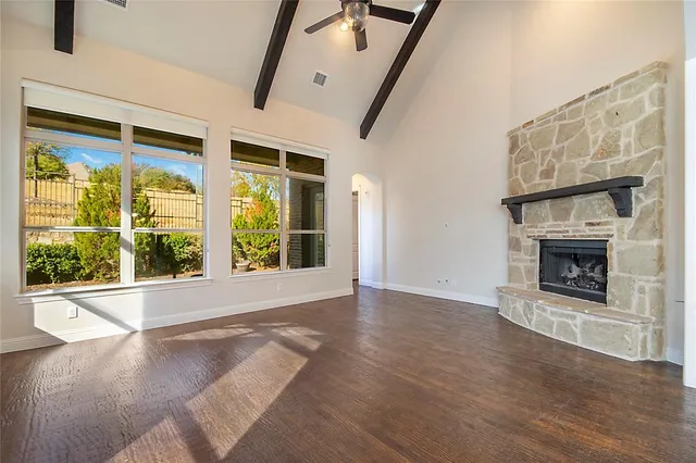a view of an empty room with a fireplace and a window