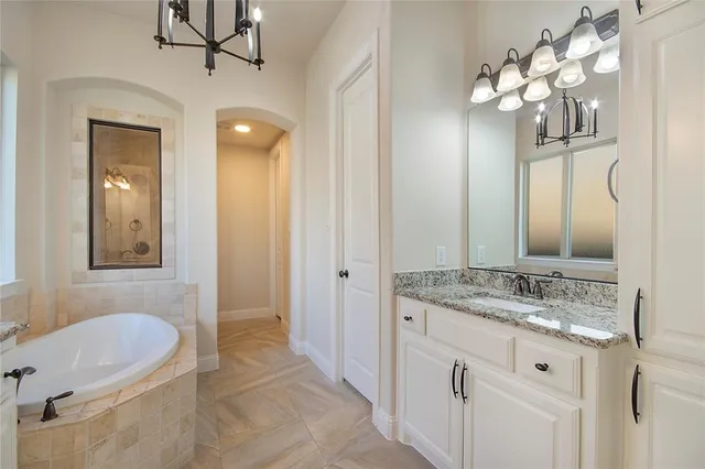 a bathroom with a granite countertop sink a light fixture and a mirror