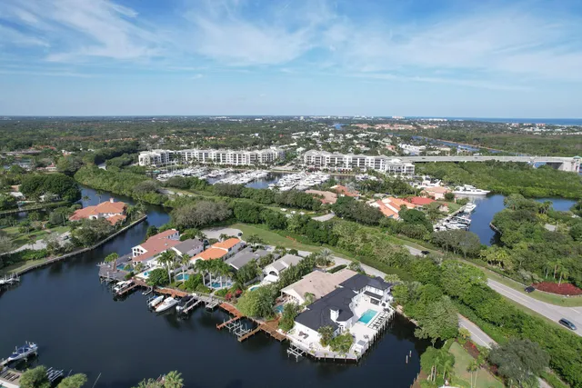 an aerial view of a city with lots of residential buildings ocean and mountain view in back