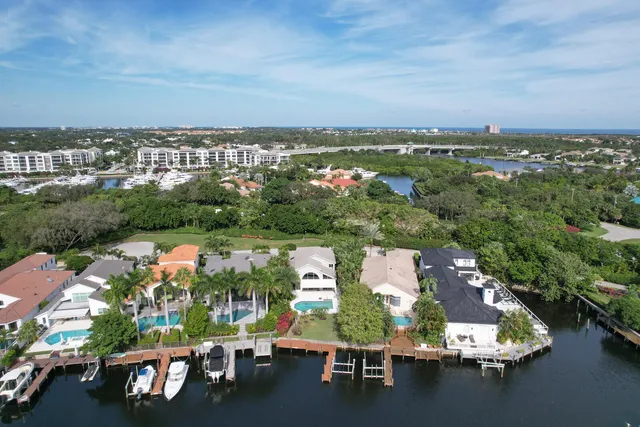 an aerial view of a city with lots of residential buildings ocean and mountain view in back