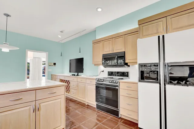a kitchen with cabinets stainless steel appliances and wooden floor
