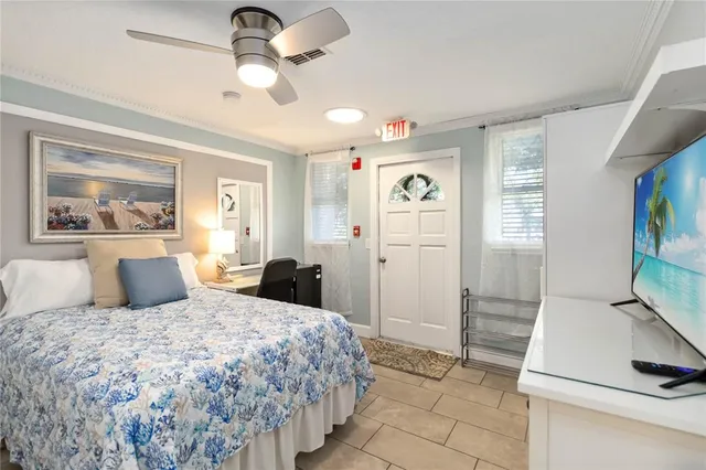 a bedroom with a bed and a flat tv screen on the dresser