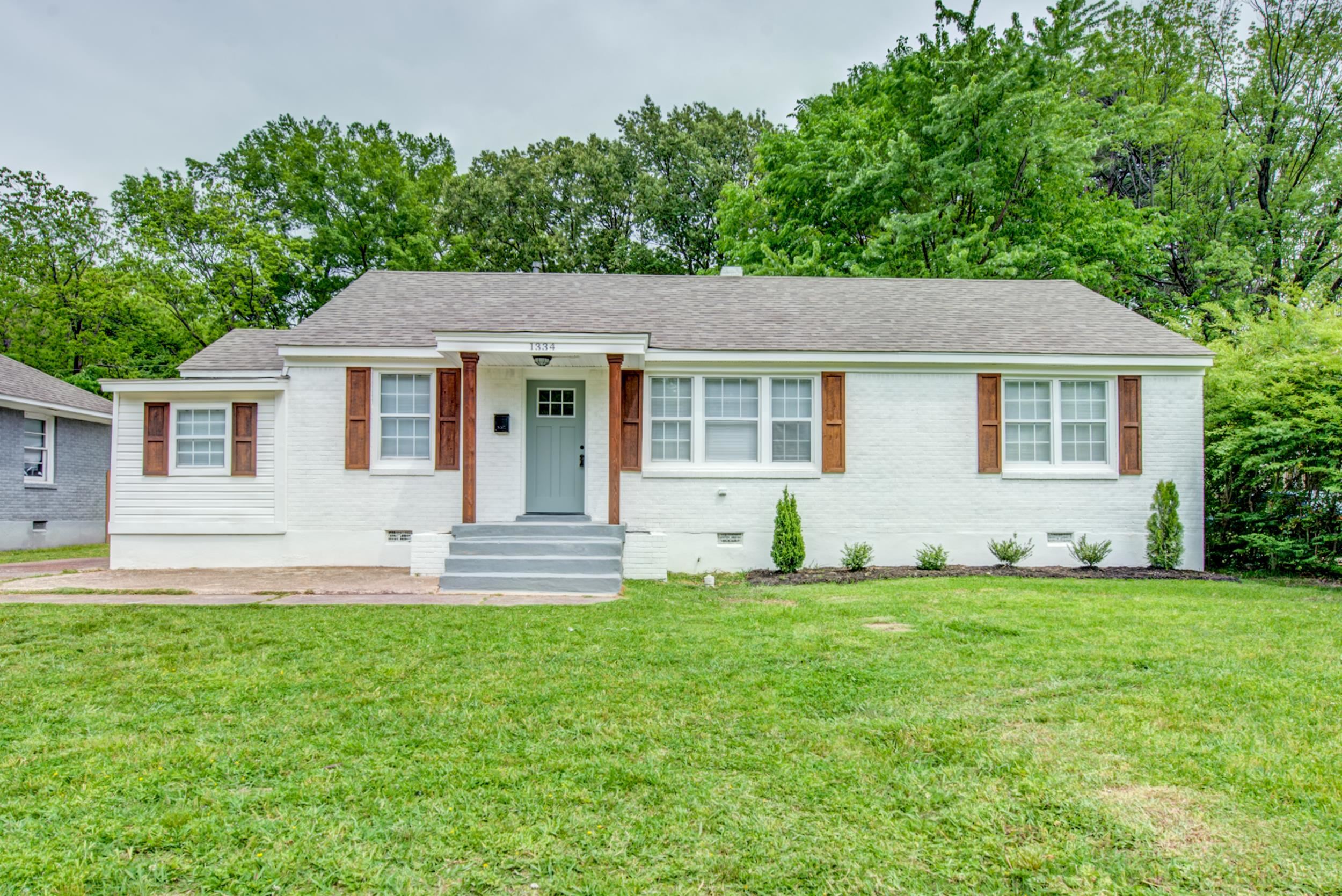 1334 South Perkins Road Memphis, TN 38117 - Photo 1 of 21 a front view of a house with a yard and trees