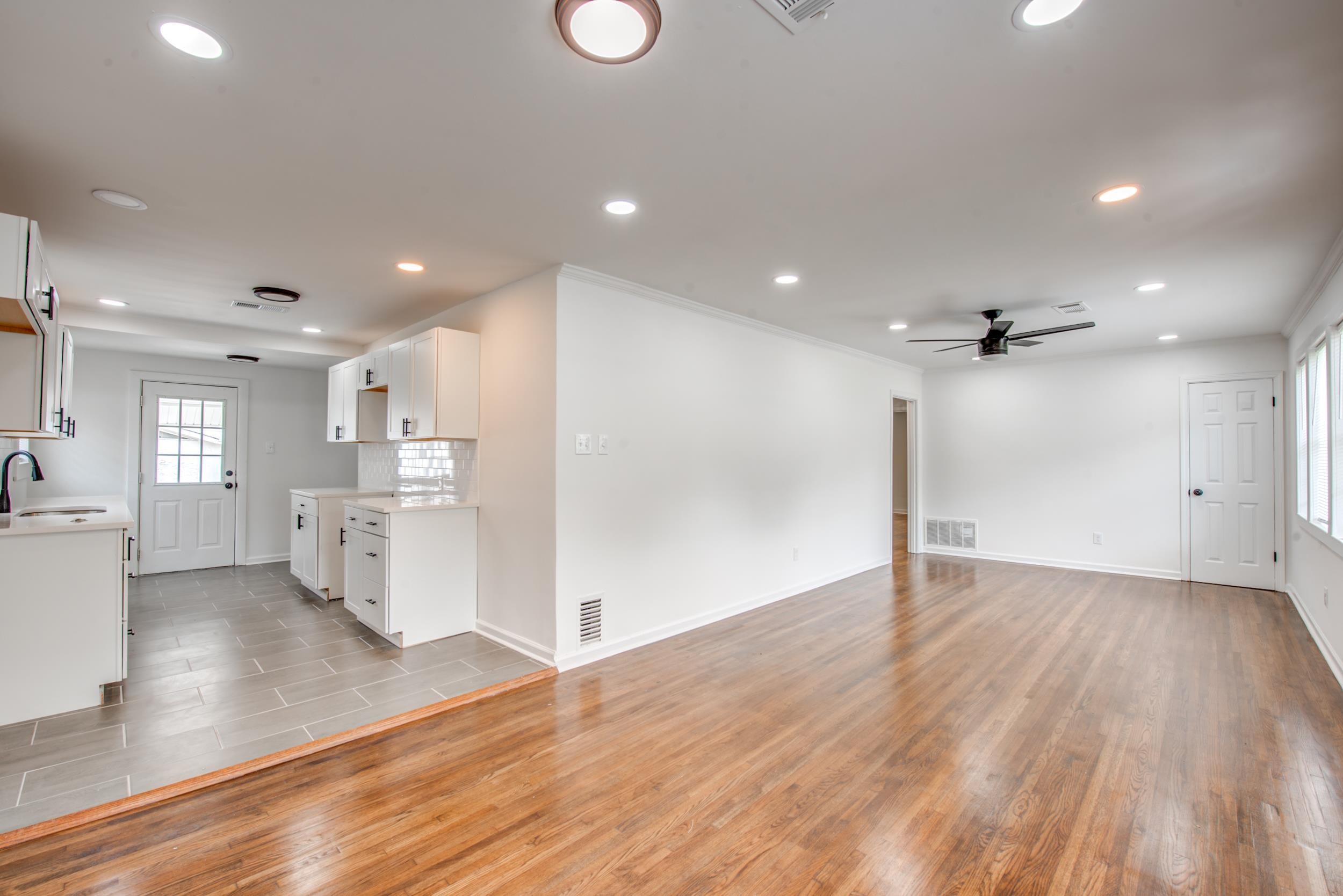 1334 South Perkins Road Memphis, TN 38117 - Photo 4 of 21 an empty room with wooden floor and a kitchen