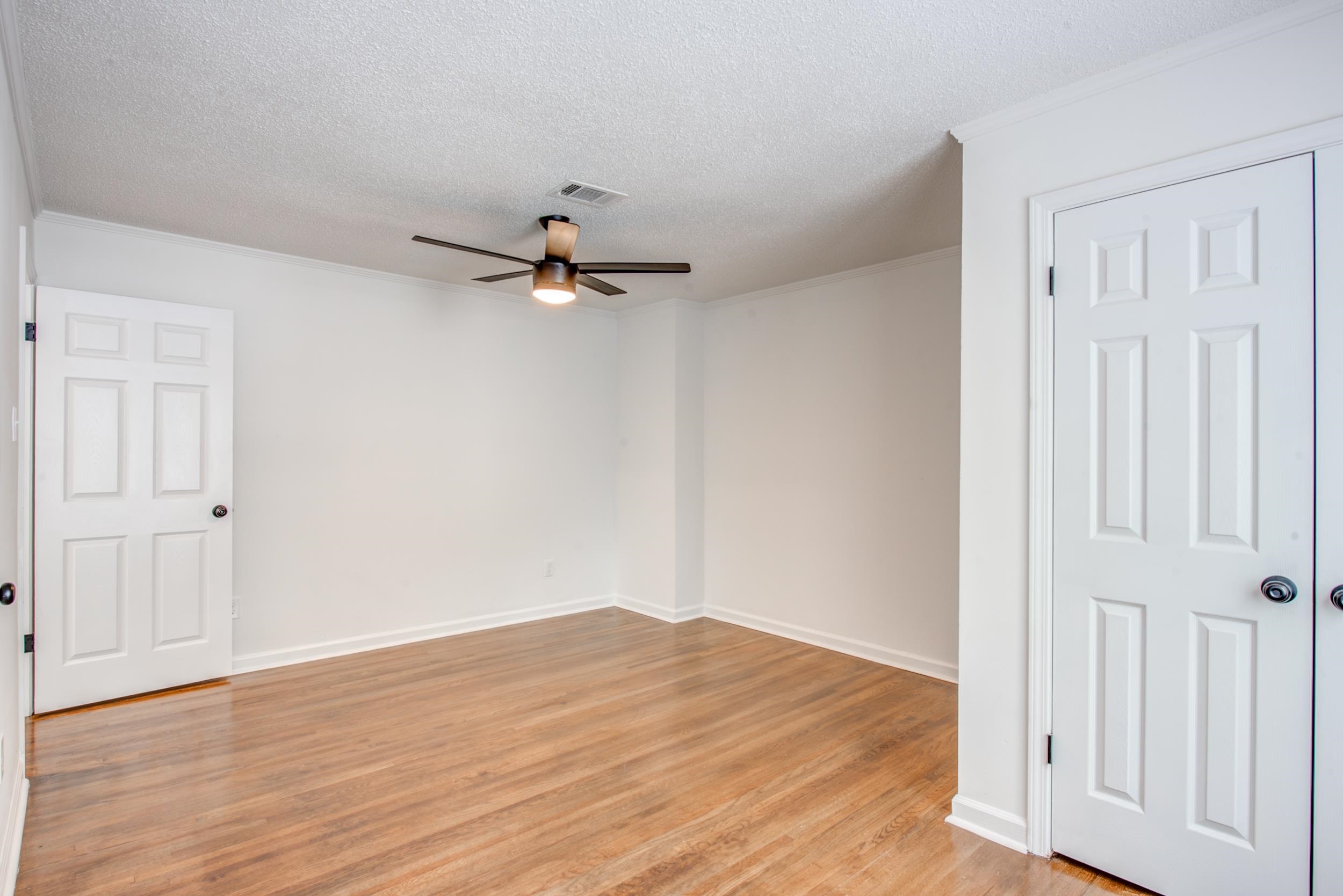 1334 South Perkins Road Memphis, TN 38117 - Photo 6 of 21 a view of a livingroom with a wooden floor and a ceiling fan