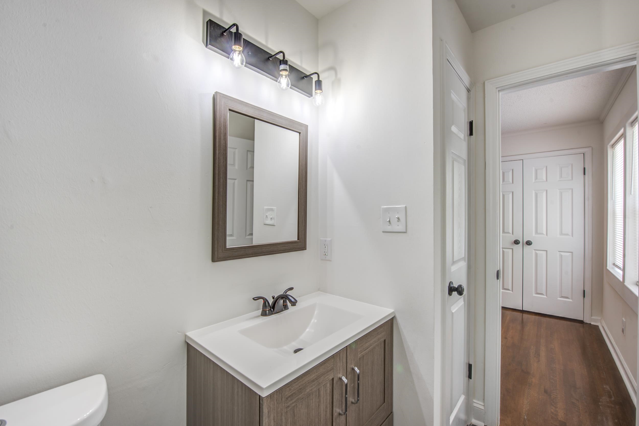 1334 South Perkins Road Memphis, TN 38117 - Photo 8 of 21 a bathroom with a toilet sink vanity and mirror