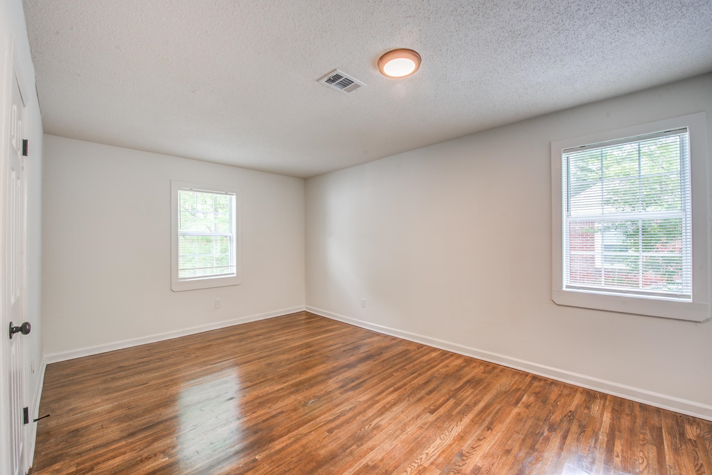 1334 South Perkins Road Memphis, TN 38117 - Photo 9 of 21 an empty room with wooden floor and windows