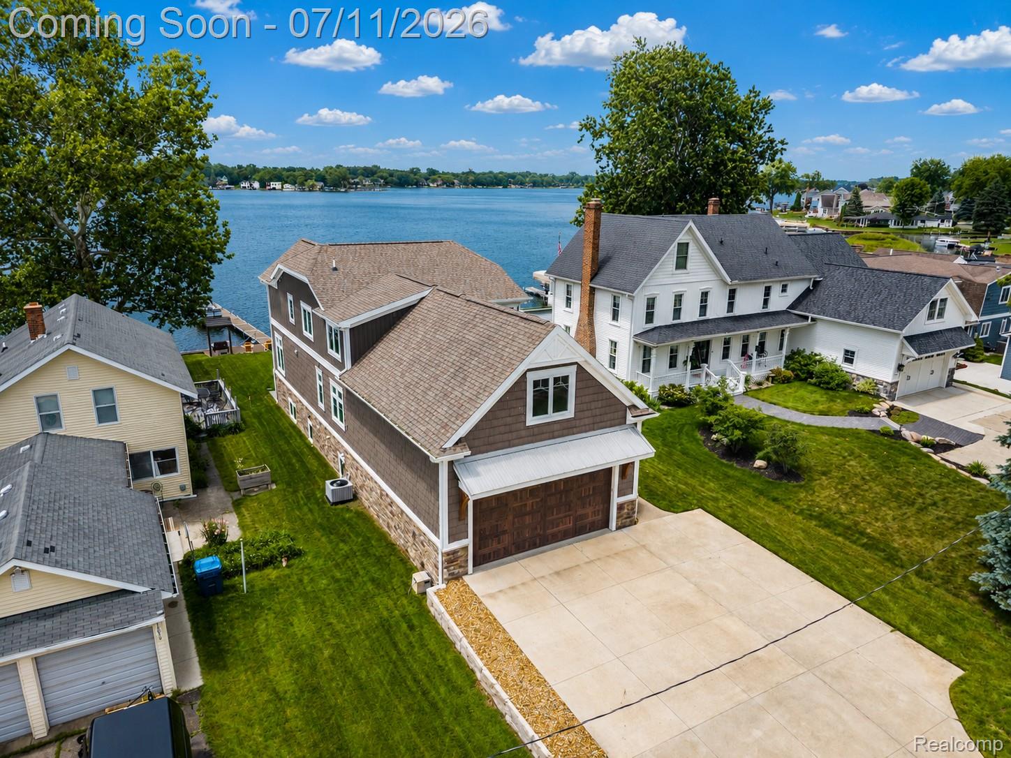 12033 Torrey Road Fenton, MI 48430 - Photo 9 of 51 Waterfront property featuring a detached three-story residence with brown siding and stone veneer