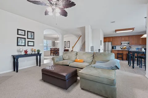 a living room with furniture kitchen view and a wooden floor