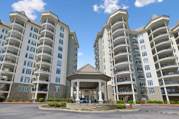 a front view of a multi story residential apartment building with yard