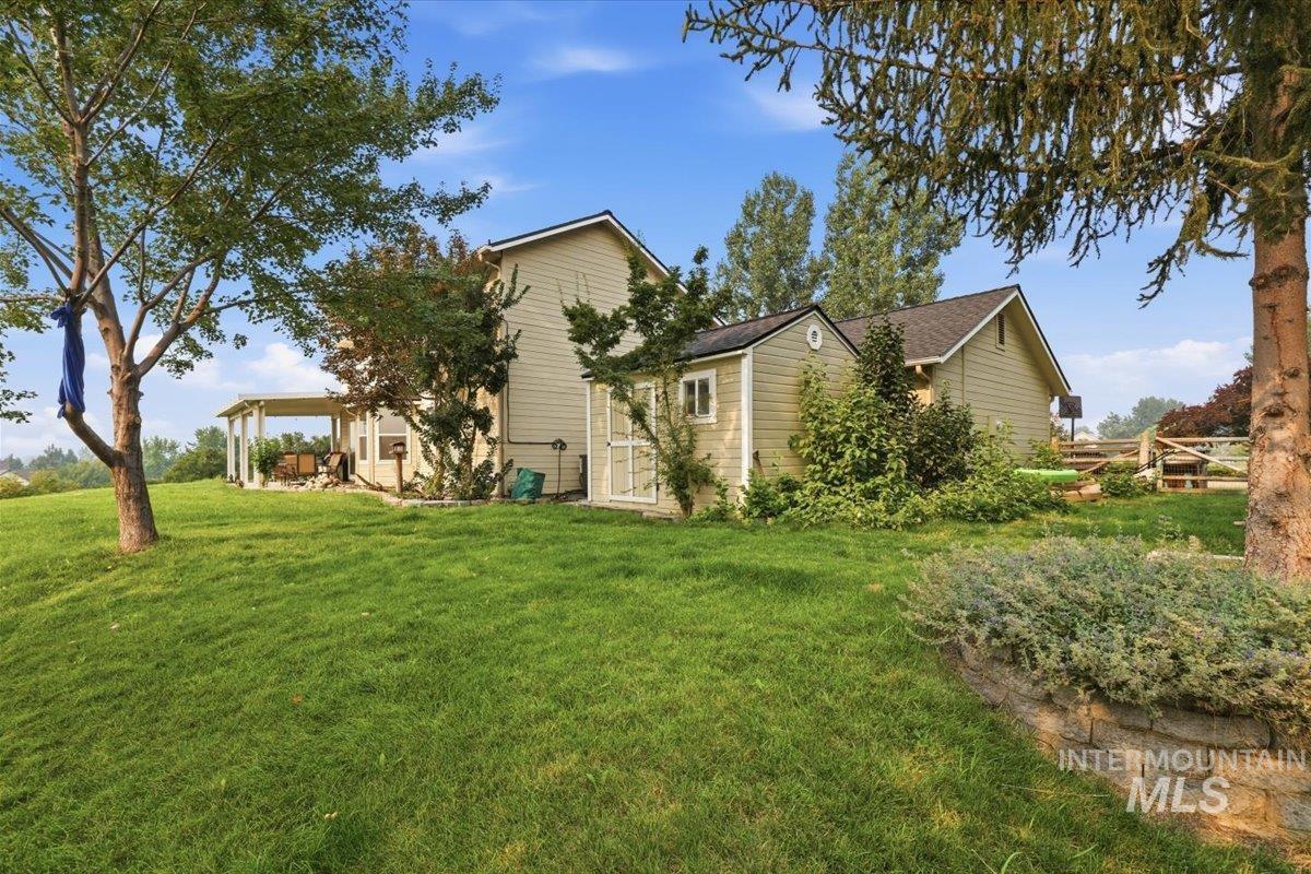 24440 Kenridge Road Caldwell, ID 83607 - Photo 44 of 48 Expansive green lawn with mature trees and a stone retaining wall