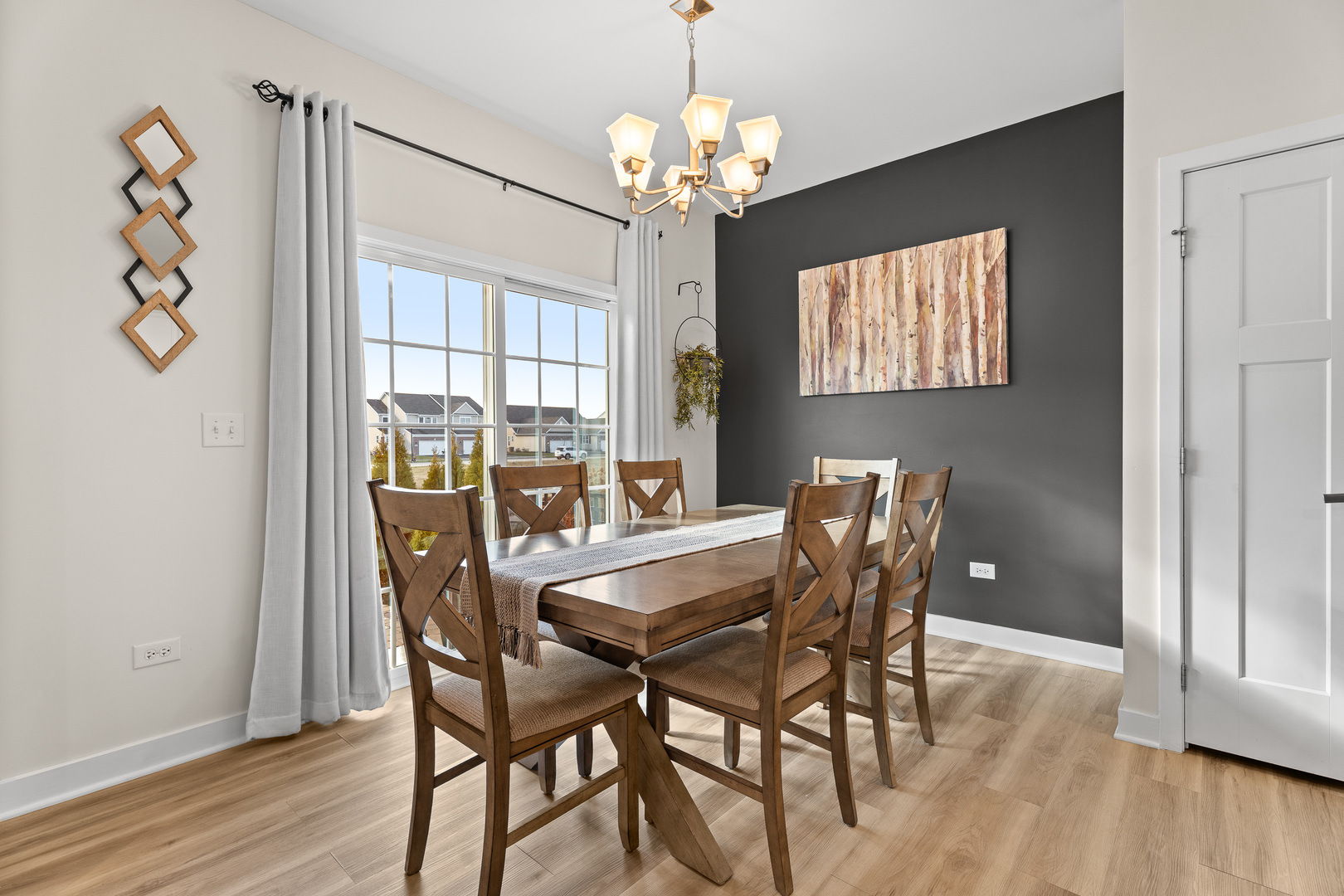 1053 Sears Circle Elburn, IL 60119 - Photo 9 of 31 a dining room with wooden floor a chandelier a wooden table and chairs