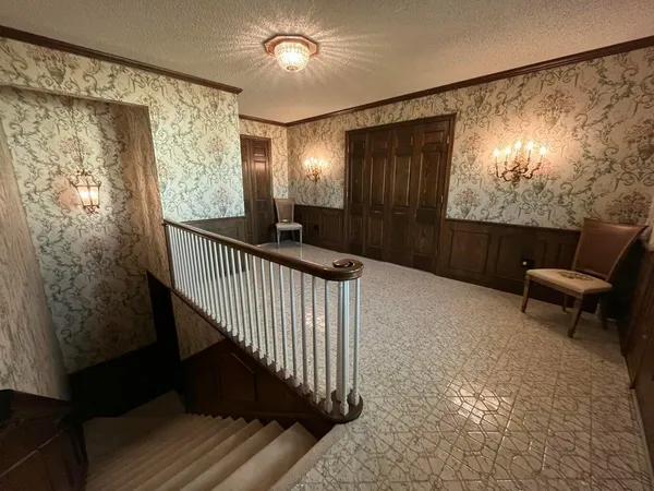a view of a hallway with wooden floor and stairs