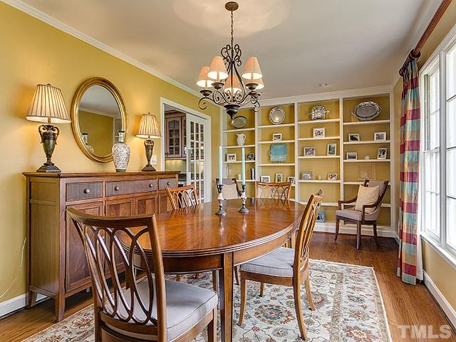 609 Ortega Road Raleigh, NC 27609 - Photo 11 of 25 a dining room with furniture a chandelier and wooden floor