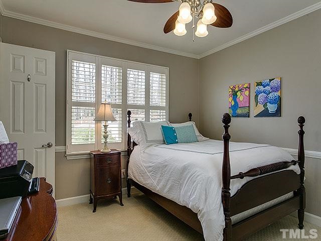 609 Ortega Road Raleigh, NC 27609 - Photo 22 of 25 a bedroom with a bed and a chandelier
