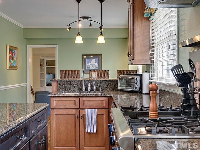 609 Ortega Road Raleigh, NC 27609 - Photo 5 of 25 a kitchen with stainless steel appliances granite countertop a stove top oven a sink dishwasher and a microwave oven on the granite countertops