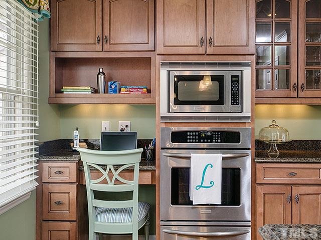 609 Ortega Road Raleigh, NC 27609 - Photo 7 of 25 a stove top oven sitting inside of a kitchen and granite counter tops